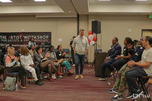 Panelist Charles Newman walking to his chair alongside Curtis Elerson, A'Noelle Jackson, Shyan Selah and John Silva at The Artist Workshop: Career Day