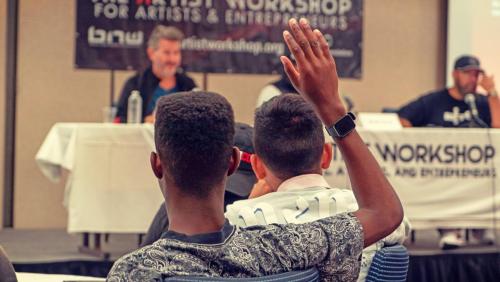 An attendee waits to ask the panelists a question at The Artist Workshop: The Long Money Game.